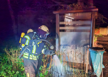 Feuerwehr Tecklenburg löscht Brand - Feuerwehrmann mit Atemschutz bei Unterstand der Klnik Tecklenburger Land